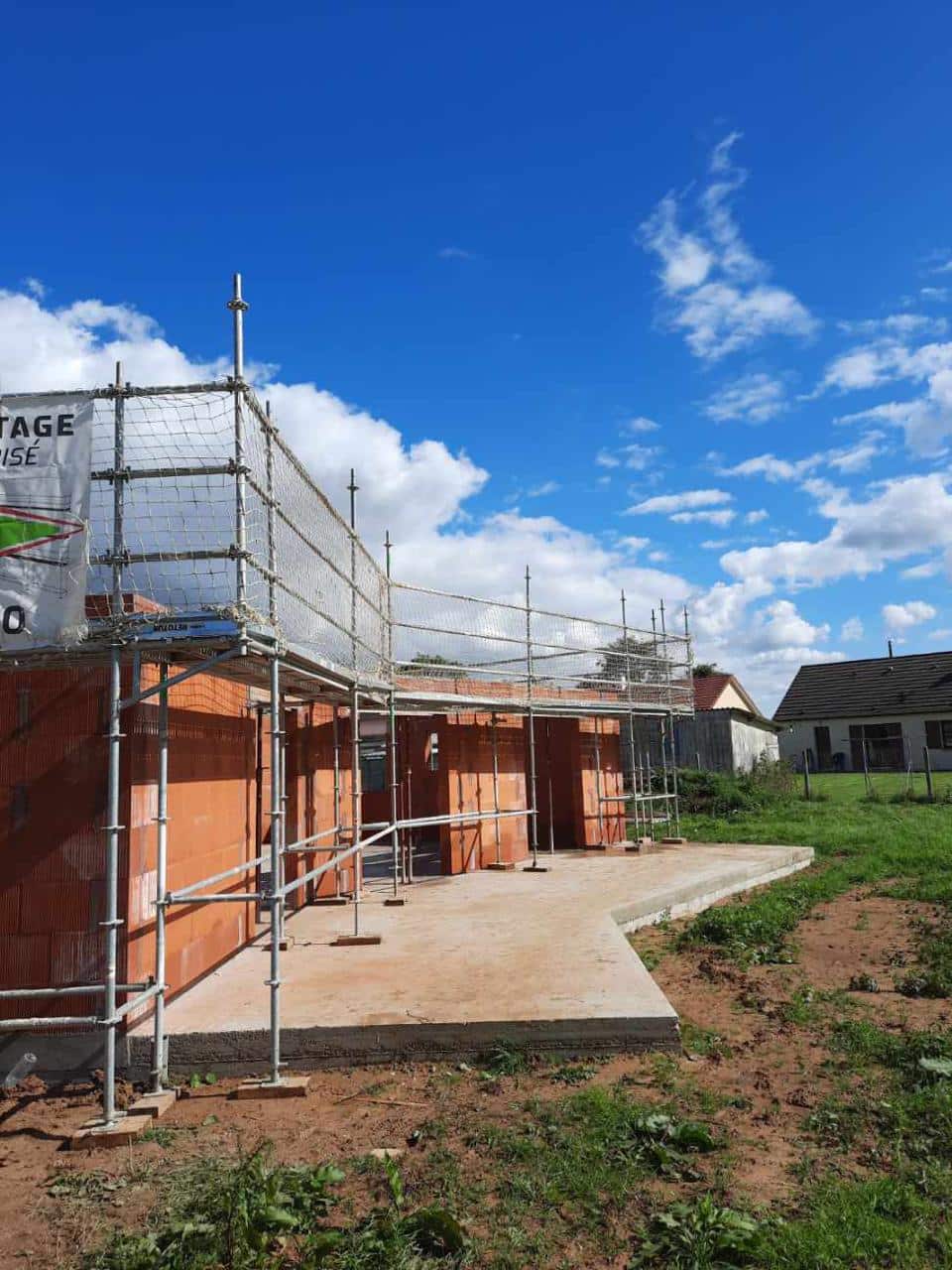 Chantier de maison neuve avec échafaudage de façade